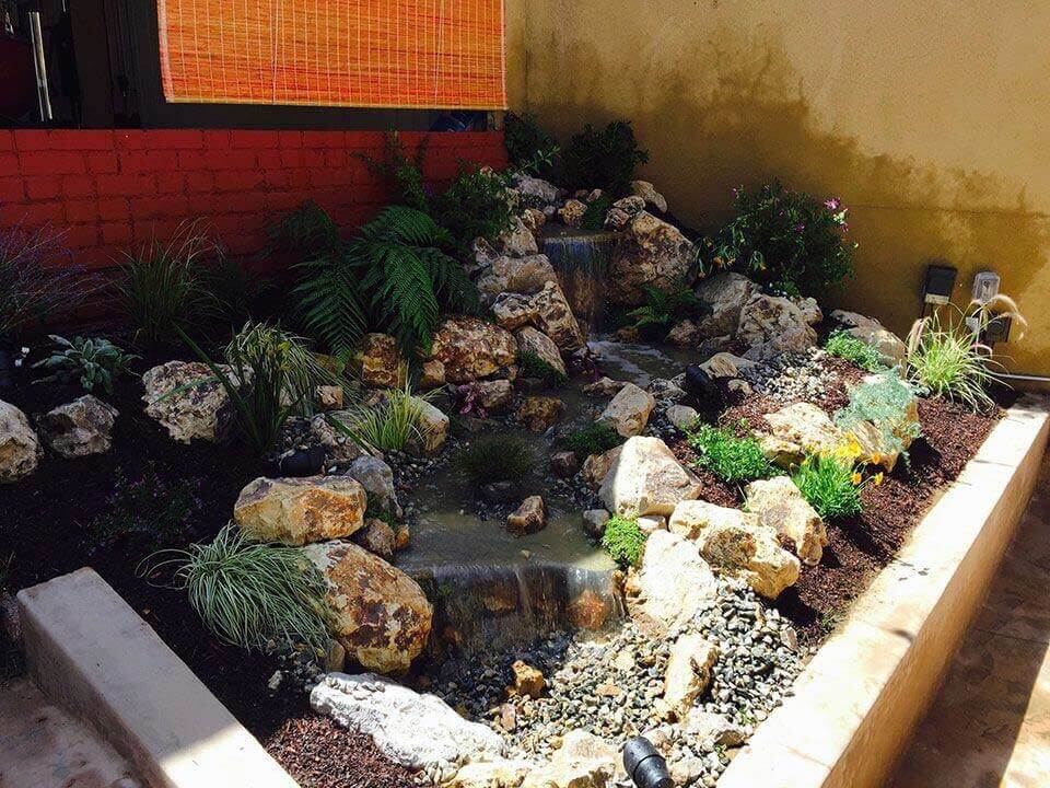 Tiered custom waterfall installation in Los Angeles with ferns