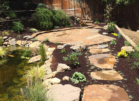 a beautiful hardscaping with a pond created by our pros