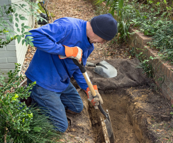 Landscaper in Tarzana digs trench to install a new in-ground sprinkler system